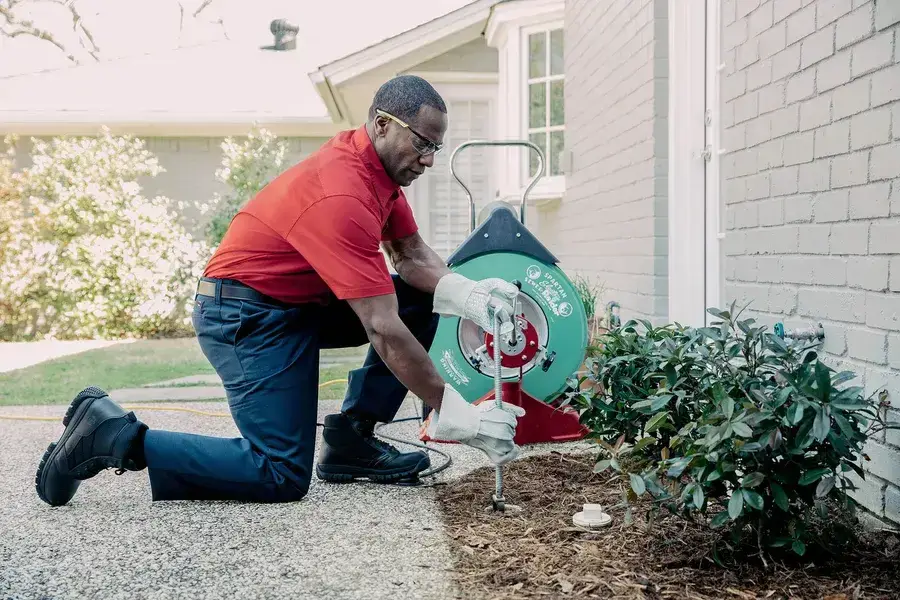 Technician using drain snake equipment