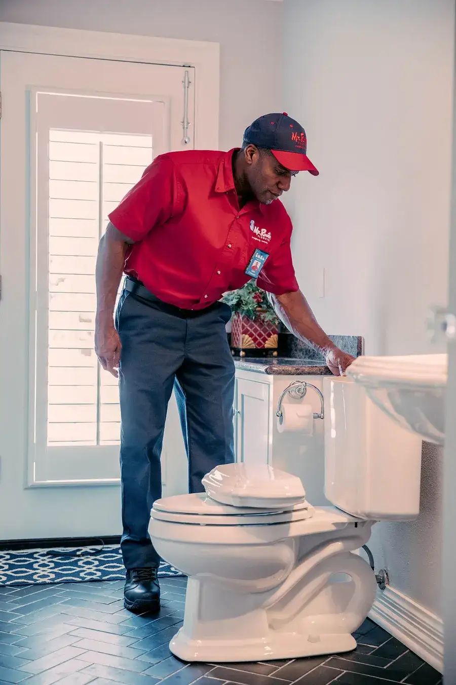 Technician inspecting toilet plumbing